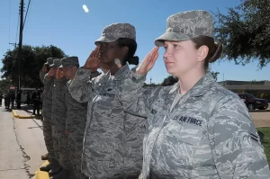 Thank you for your service! Image of Service Members in uniform saluting the U.S. flag as it passes in a Veterans Day Parade